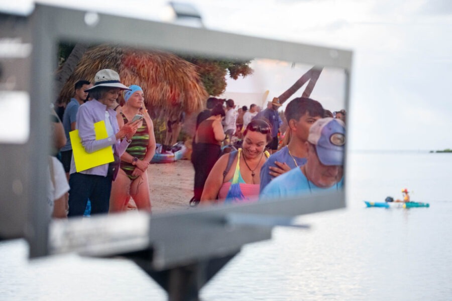 a mirror reflecting a group of people on a beach