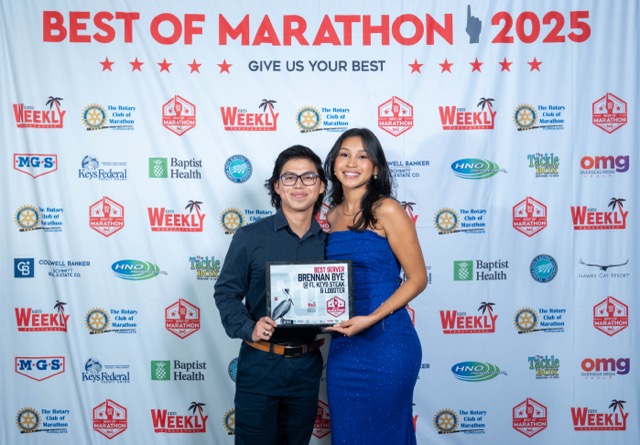 a man standing next to a woman in a blue dress
