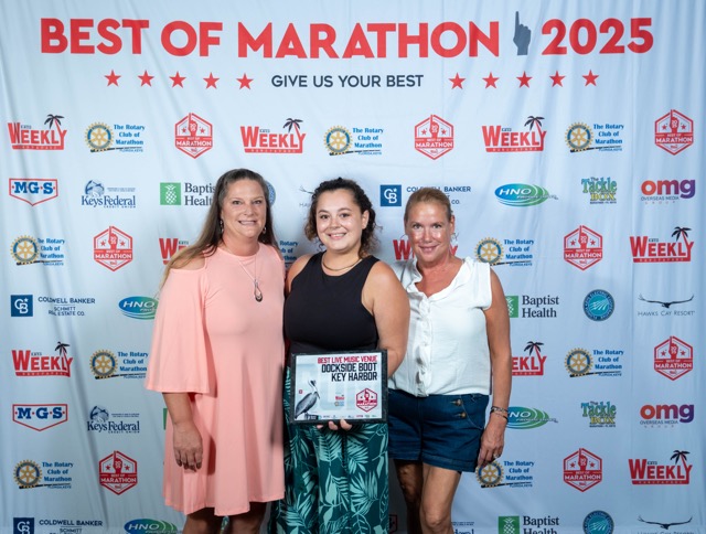 three women standing in front of a banner