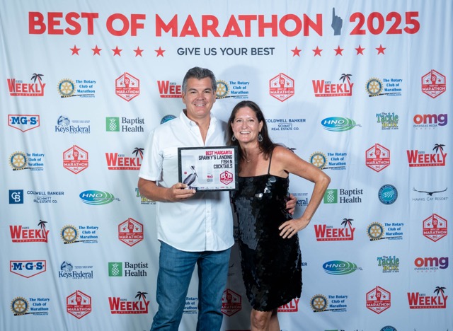 a man and a woman standing in front of a sign
