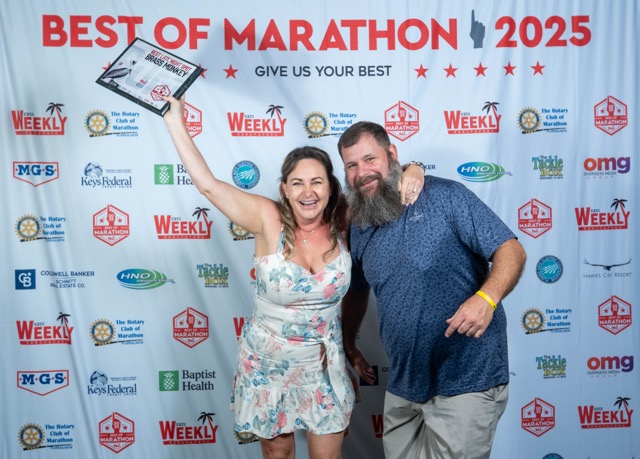 a man and a woman standing in front of a sign