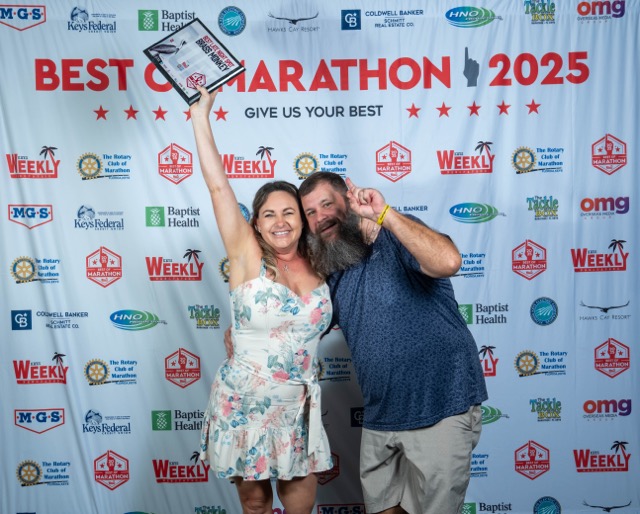 a man and a woman holding up a plaque