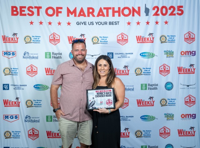 a man and a woman standing in front of a sign