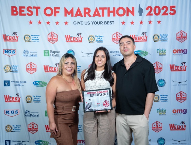 a man and two women standing in front of a sign