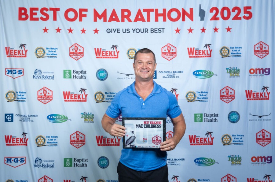 a man in a blue shirt holding a plaque