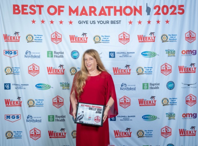 a woman in a red dress holding a plaque