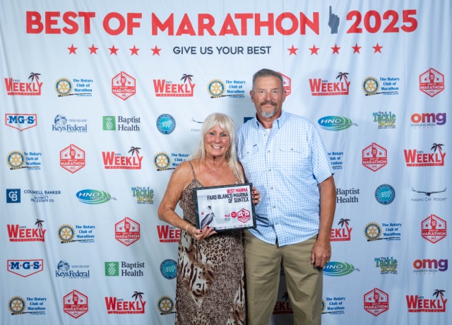 a man and a woman standing in front of a sign