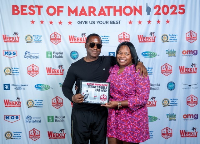 a man and a woman standing in front of a sign