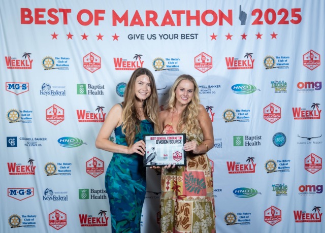 two women standing next to each other holding a plaque