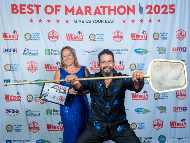 a man and a woman posing for a picture with a paddle