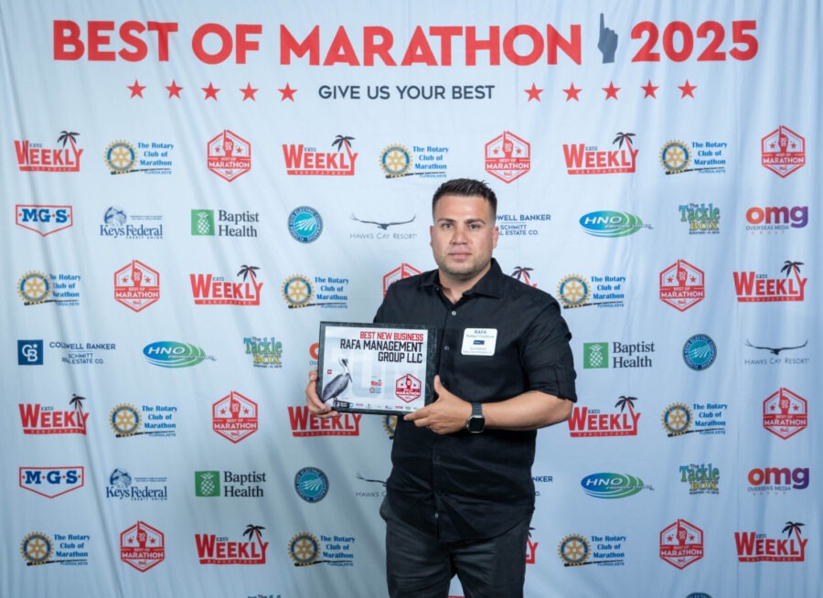 a man standing in front of a wall holding a plaque