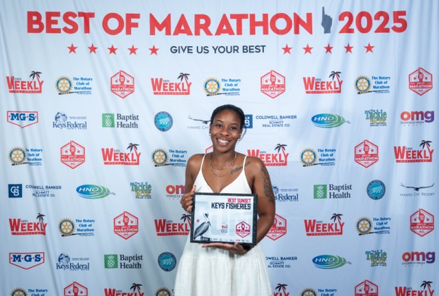 a woman in a white dress holding a plaque