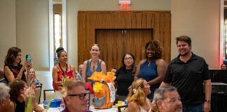 a group of people sitting around a table clapping
