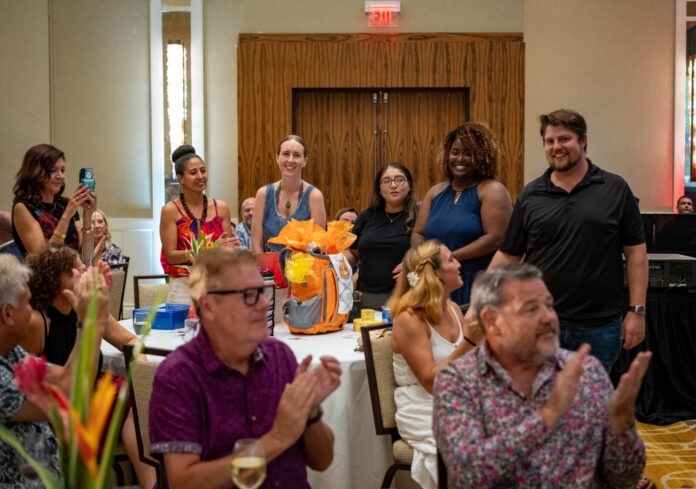 a group of people sitting around a table clapping