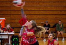 a group of girls playing a game of volleyball