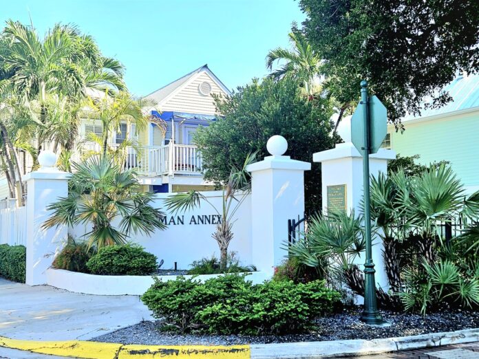 a street with a yellow caution tape in front of a white building