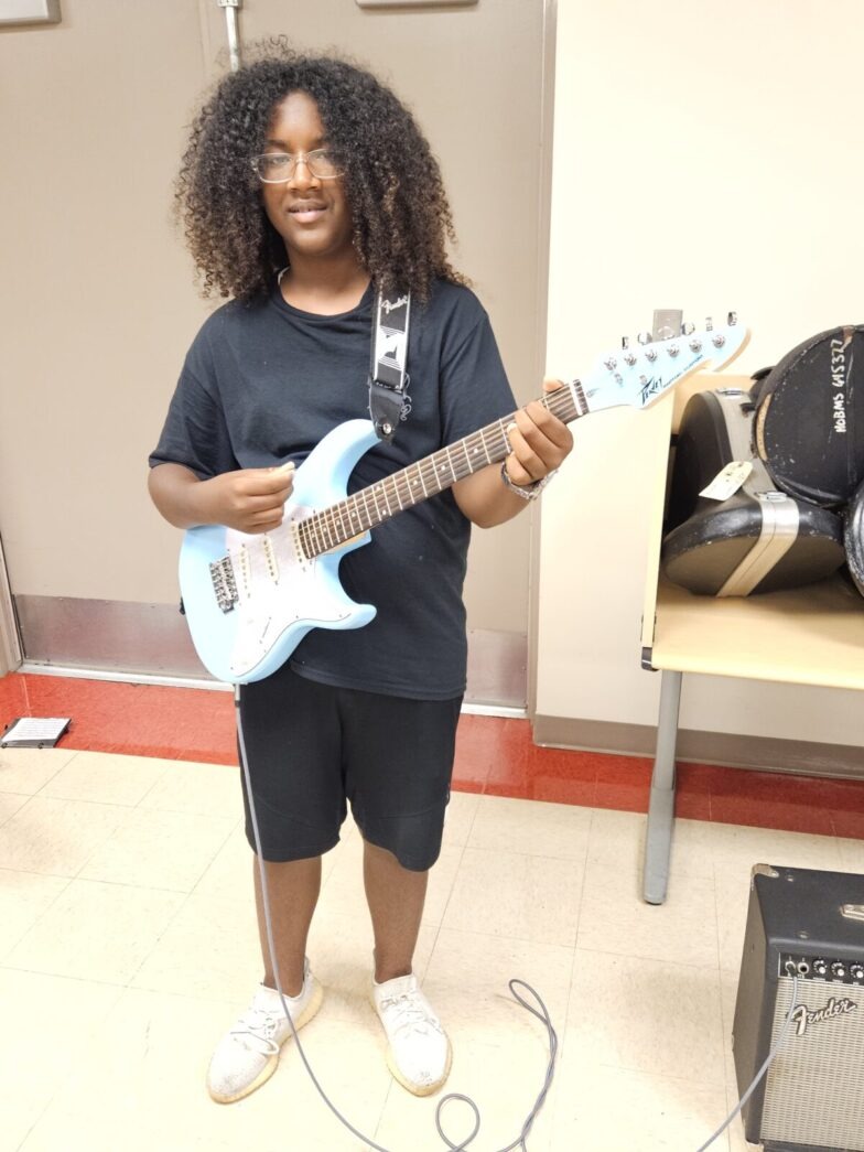 a woman standing in a room with a guitar