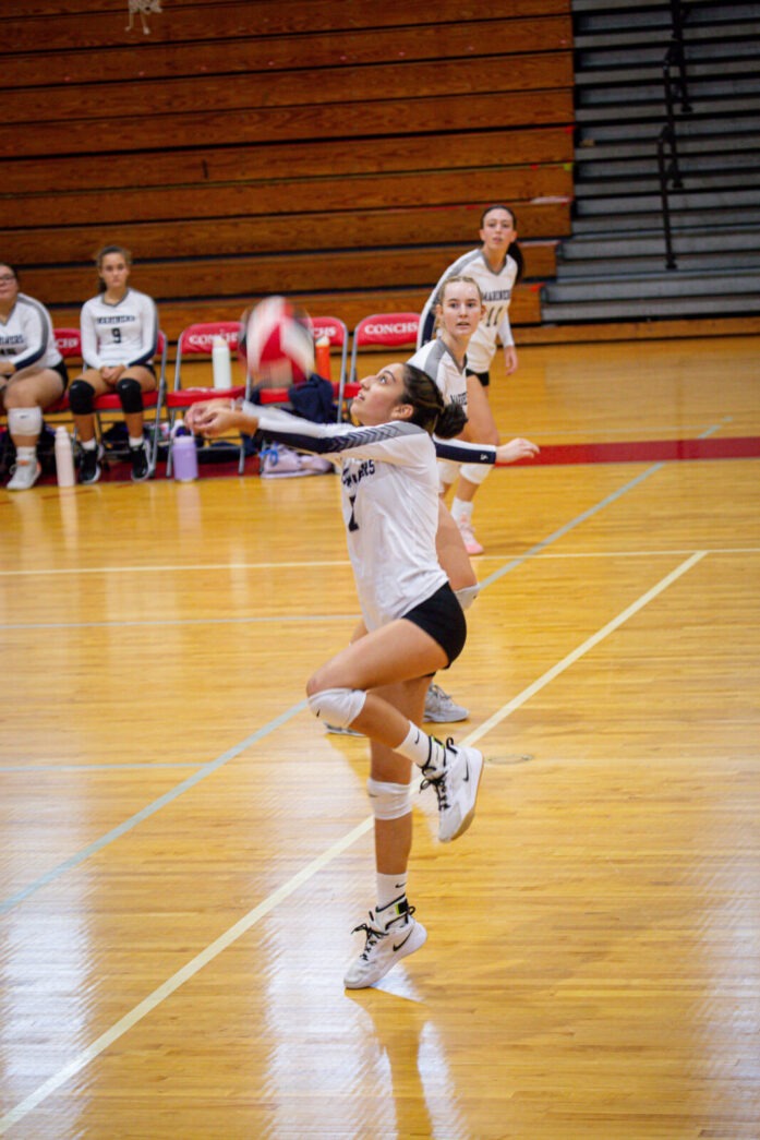 a group of young women playing a game of volleyball