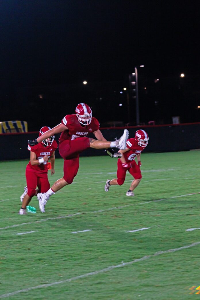 a group of football players standing on top of a field