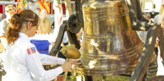 a woman in a uniform is holding a bell