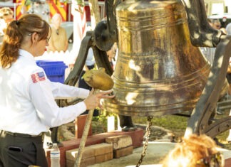 a woman in a uniform is holding a bell