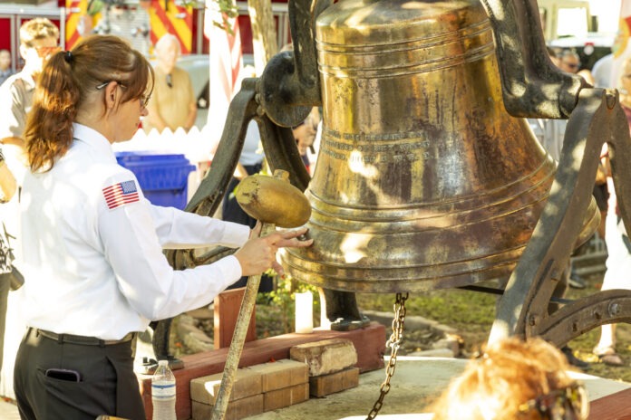 a woman in a uniform is holding a bell