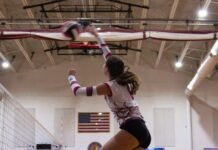 a volleyball player jumping up to hit the ball