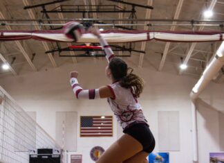 a volleyball player jumping up to hit the ball