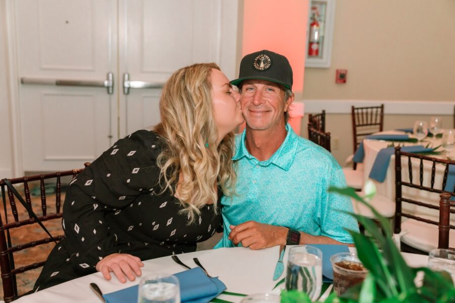 a man and woman kissing each other at a table