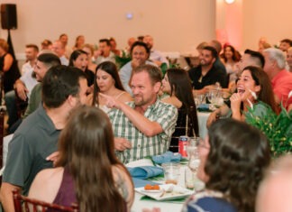 a large group of people sitting at tables in a room