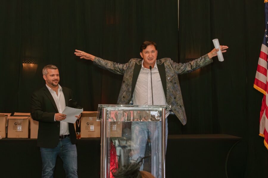 a man standing at a podium with his arms wide open