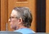 a man sitting in a chair in a courtroom