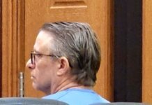 a man sitting in a chair in a courtroom
