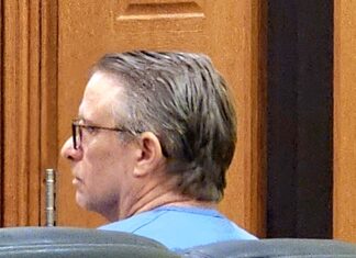 a man sitting in a chair in a courtroom