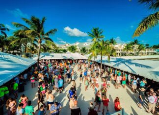 a crowd of people walking down a street next to palm trees