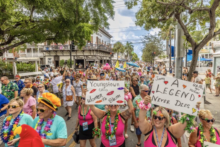 a group of people walking down a street holding signs