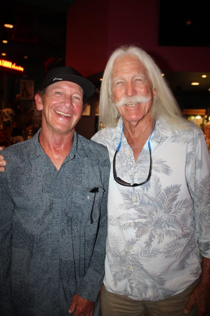 two men standing next to each other in a room