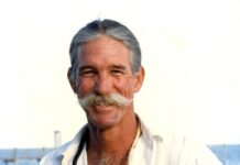 a man with a mustache and a white shirt
