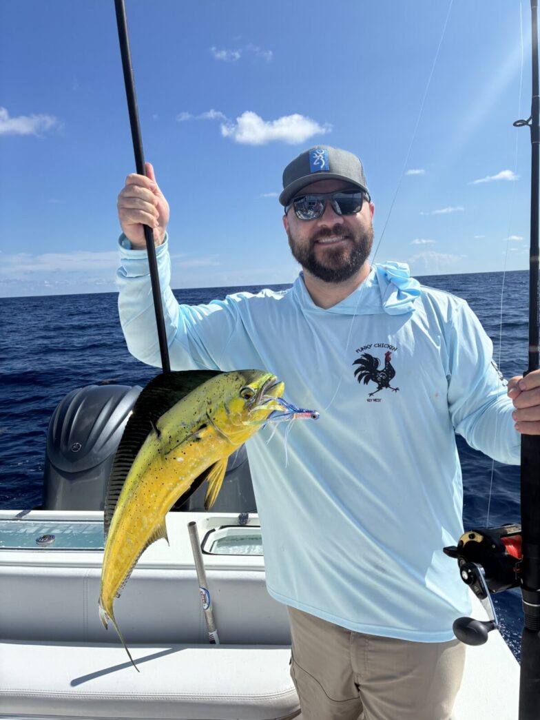 a man holding a fish on a boat