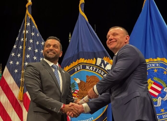 two men shaking hands in front of flags