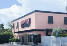 a pink building with a white fence in front of it