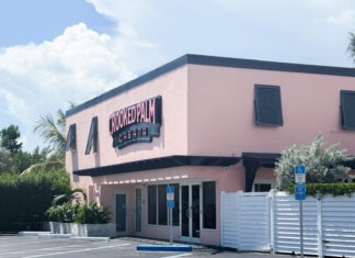 a pink building with a white fence in front of it