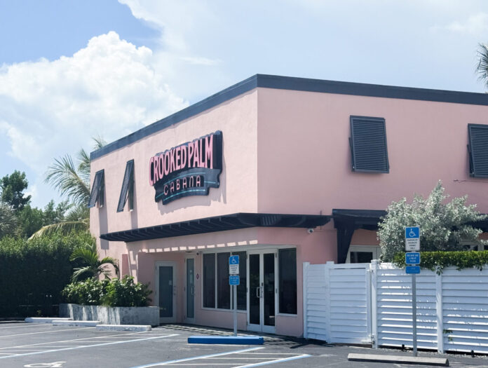 a pink building with a white fence in front of it