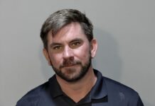 a mug shot of a man in a blue shirt