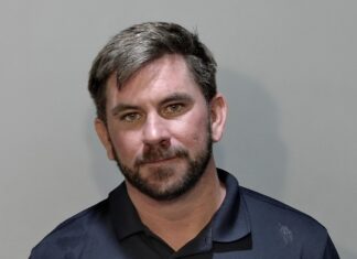a mug shot of a man in a blue shirt