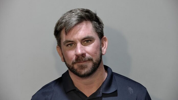 a mug shot of a man in a blue shirt