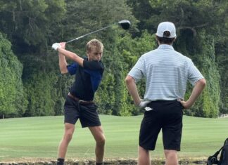 a man swinging a golf club on a golf course