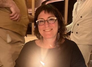 a woman sitting at a table with a cake in front of her