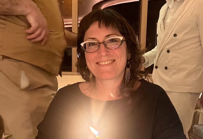 a woman sitting at a table with a cake in front of her