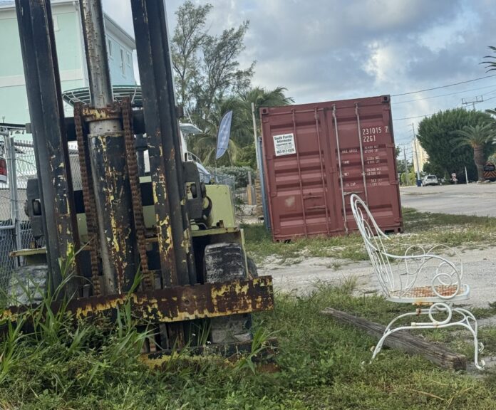 IMG_5323 a chair sitting in the grass next to a forklift